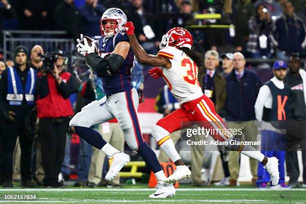 Rob Gronkowski of the New England Patriots makes a catch while under pressure from Josh Shaw of the Kansas City Chiefs in the fourth quarter of a...