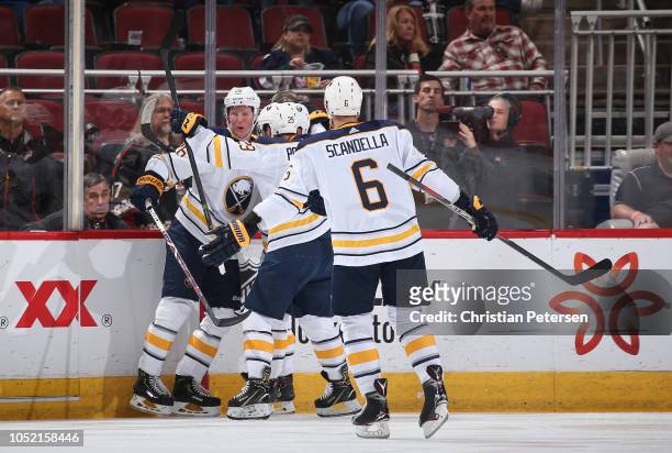 Rasmus Dahlin of the Buffalo Sabres celebrates with Jason Pominville and Marco Scandella after scoring his first career goal against the Arizona...