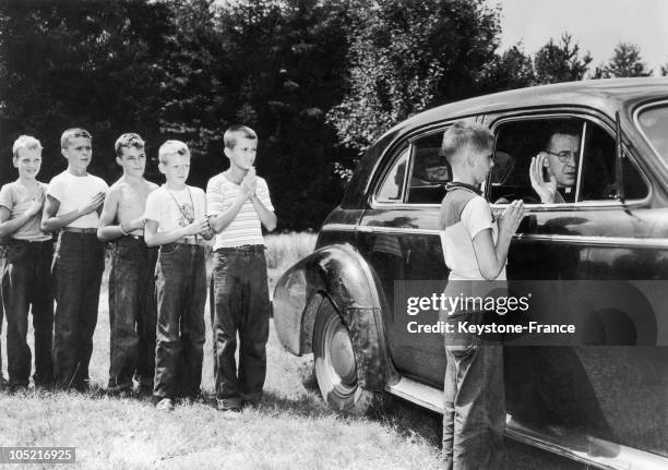 Catholic Priest Listening To Soem Young Scouths Confessing While Sitting In His Car In Seqoyah Camp, Pennsylvania.