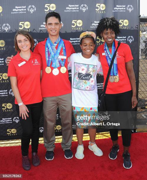 Special Olmpics athletes Brett Laza, Kyla Schilz and Krystal Johnson pose with Jailen Bates at the Special Olympics Pier Del Sol held at Pacific Park...