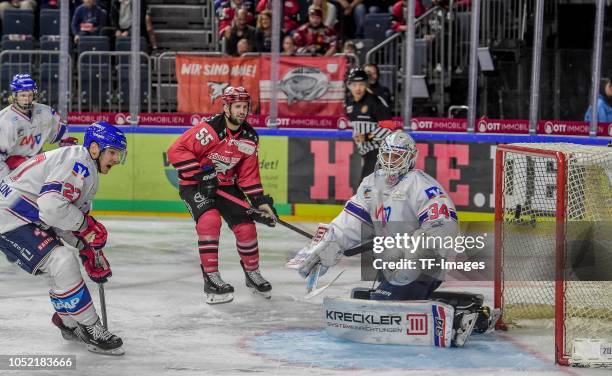 Chet Pickard of Adler Mannheim, Felix Schuetz of Koelner Haie and Brendan Mikkelson of Adler Mannheim battle for the ball during the DEL match...