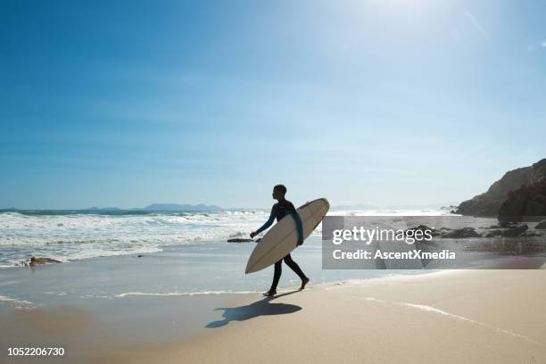 homme va surfer le long d’un littoral magnifique - man wearing cap photos et images de collection