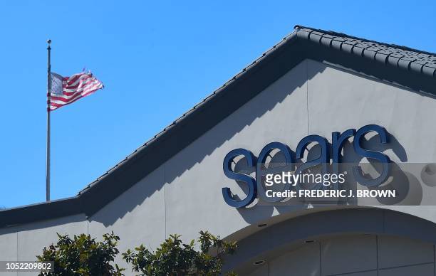 Flag flies beside the entrance to a Sears store in Montebello, California on October 15, 2018. Sears, an anchor of retail life for generations of...