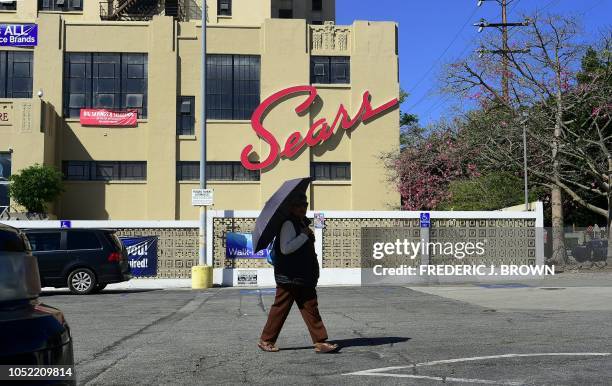 Pedestrian walks past a Sears store in the Boyle heights neighborhood of Los Angeles, California on October 15, 2018. Sears, an anchor of retail life...