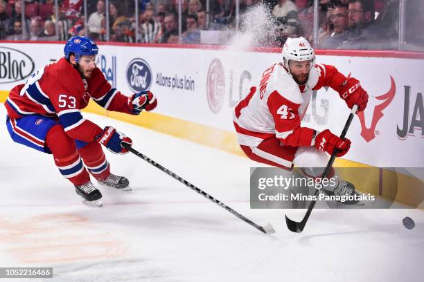 Luke Glendening of the Detroit Red Wings and Victor Mete of the Montreal Canadiens chase the puck during the NHL game at the Bell Centre on October...