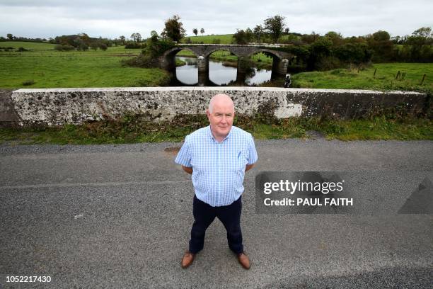 Resident John Connolly pose on the Finn bridge, the centre of which marks the dividing line between Ireland and Northern Ireland on the outskirts of...