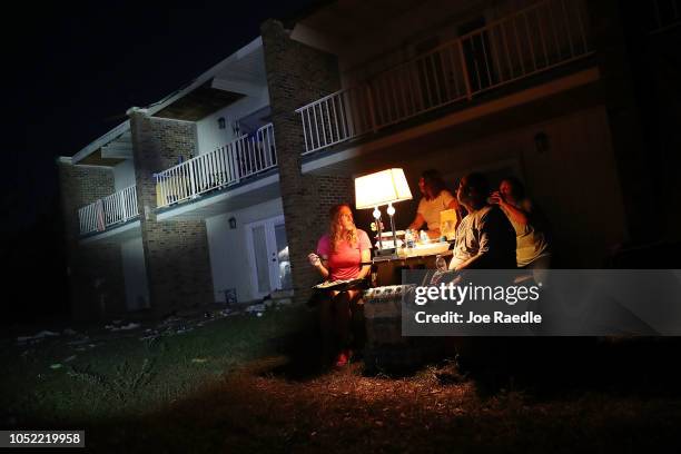 Danica Cherico and Shawn Gehlert use a generator to power a lamp as they sit outside their apartments that don't have electricty after it was damaged...