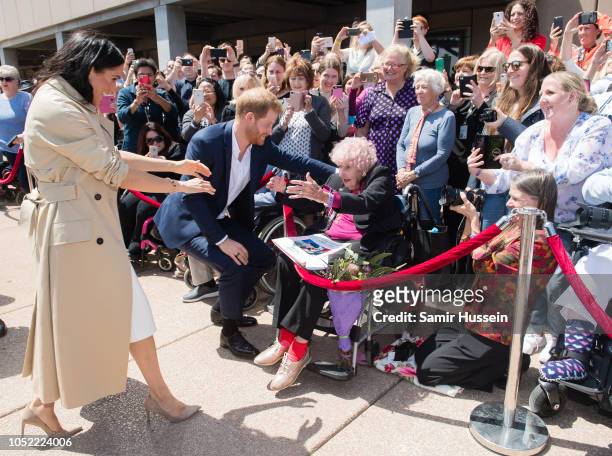 Prince Harry, Duke of Sussex and Meghan, Duchess of Sussex greet royal fan and war widow Daphne Dunne as they arrive for a public walkabout at the...