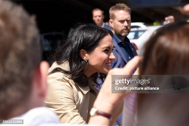 October 2018, Australia, Sydney: Duchess Meghan welcomes fans in front of the opera house. Prince Harry and his wife Meghan are on their first...