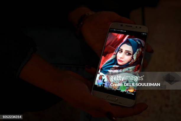Hanan shows a picture of her missing sister, Razan who was captured during a raid two years ago by jihadists of the Islamic State group, accused with...