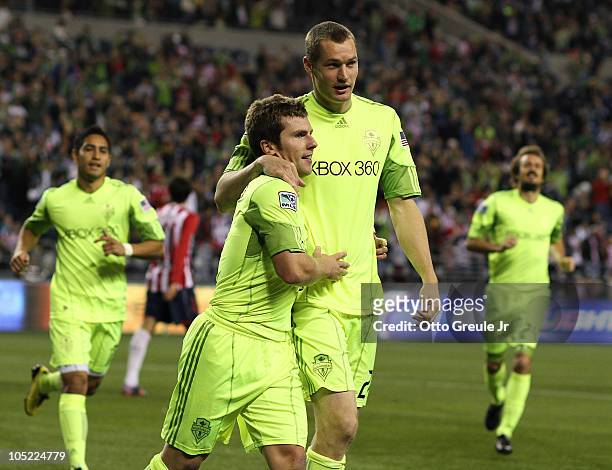 Michael Fucito of the Seattle Sounders FC gets a hug from Nate Jaqua after scoring a goal against Chivas de Guadalajara on October 12, 2010 at Qwest...