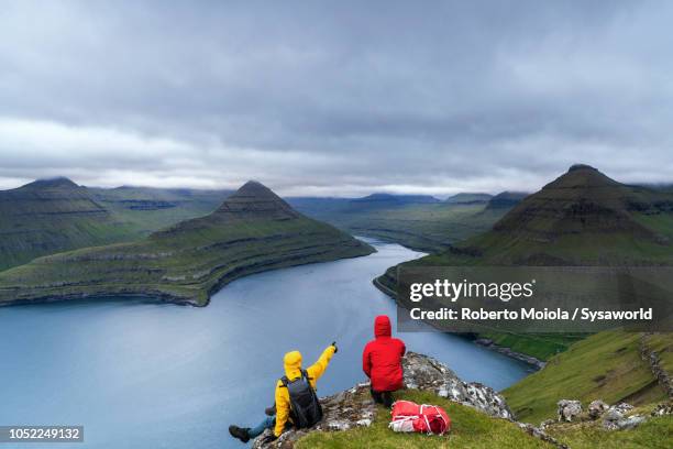 trekkers on top of cliff, eysturoy island, faroe islands - headland stock pictures, royalty-free photos & images