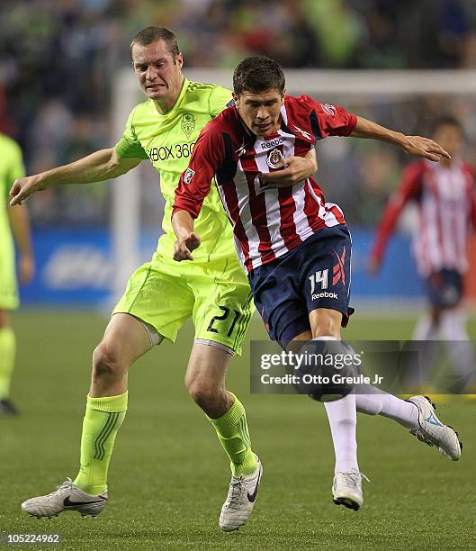 Jorge Enriquez of Chivas de Guadalajara battles Nate Jaqua of the Seattle Sounders FC on October 12, 2010 at Qwest Field in Seattle, Washington.