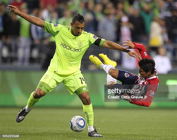 Tyrone Marshall of the Seattle Sounders FC sends Ulises Davila of Chivas de Guadalajara flying on October 12, 2010 at Qwest Field in Seattle,...