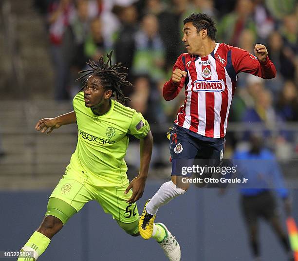 Marco Fabian of Chivas de Guadalajara watches his goal against Akeem Adams of the Seattle Sounders FC on October 12, 2010 at Qwest Field in Seattle,...