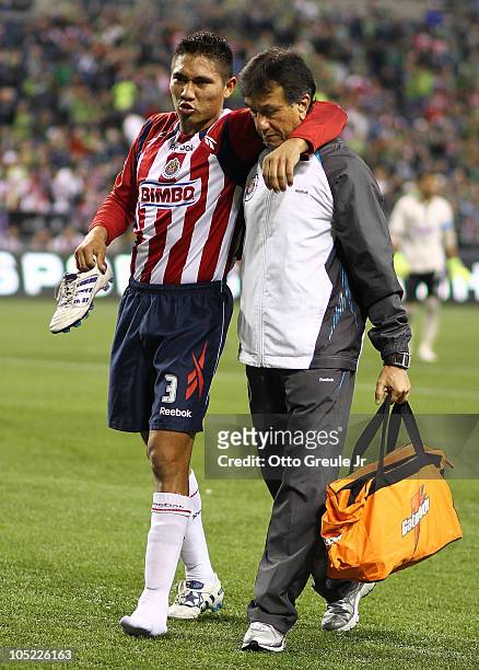 Dionicio Escalante of Chivas de Guadalajara is helped off the field after an suffering an injury against the Seattle Sounders FC on October 12, 2010...