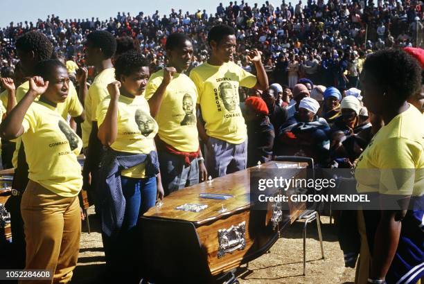 Anti-apartheid militants raise their fists in front of the coffins of four young anti-apartheid activists, victims of hand-grenade blasts, 10 July...