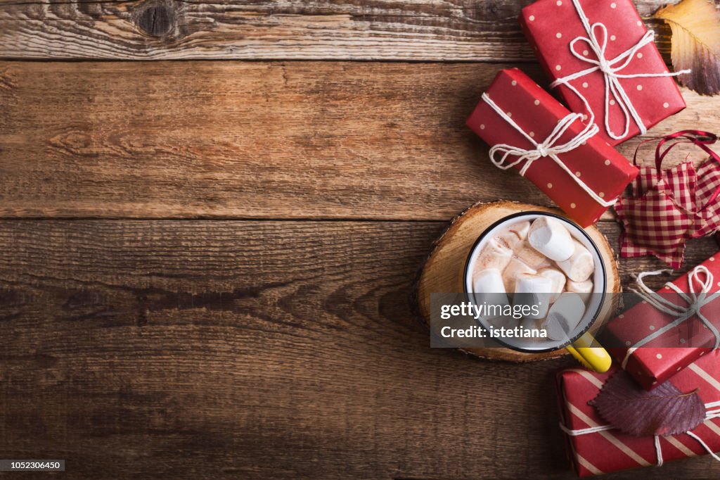 Mug of hot chocolate and Christmas gift boxes