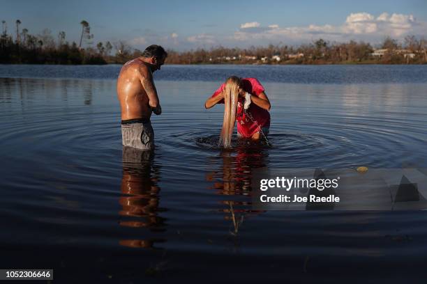 Justin Norman and Lisa Salle wash themselves in Lake Martin because their home has no running water after much of the municipality's infrastructure...