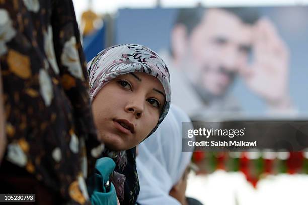 Lebanese people wave flags and hold portraits of Iranian President Mahmoud Ahmadinejad as he arrives in southern suberb of Beirut on October 13, 2010...