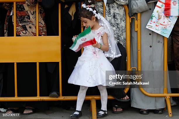 Young girl holds a flag as Lebanese people welcome Iranian President Mahmoud Ahmadinejad as he arrives in southern suberb of Beirut on October 13,...