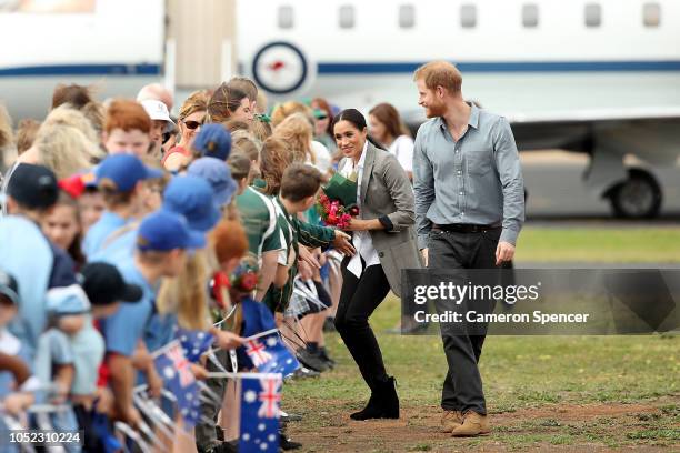 Prince Harry, Duke of Sussex and Meghan, Duchess of Sussex meet waiting public as they arrive at Dubbo Airport on October 17, 2018 in Dubbo,...