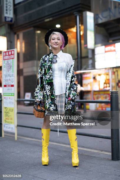 Yuri Nakagawa is seen wearing floral nylon jacket with tall yellow boots and white dress with lace corset and floral hat during the Amazon Fashion...