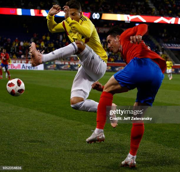 Bryan Oviedo of Costa Rica clears the ball in front of Santiago Arias of Colombia during their match at Red Bull Arena on October 16, 2018 in...