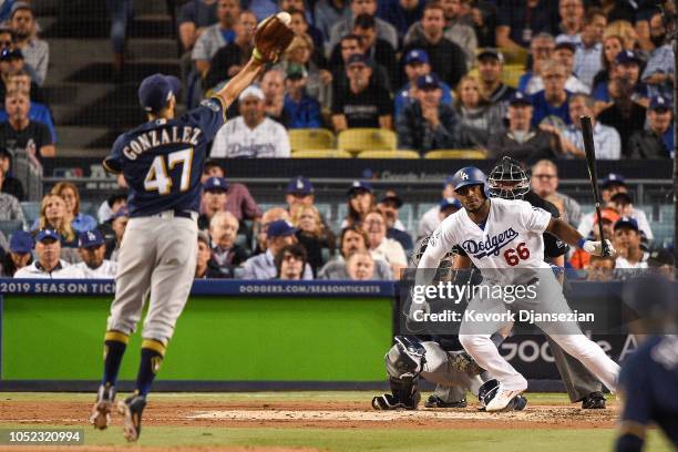 Gio Gonzalez of the Milwaukee Brewers reaches for a ball hit by Yasiel Puig of the Los Angeles Dodgers during the second inning in Game Four of the...