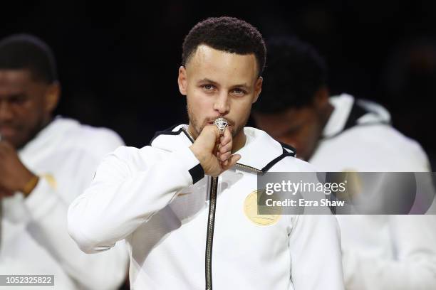 Stephen Curry of the Golden State Warriors kisses at his 2017-2018 Championship ring prior to their game against the Oklahoma City Thunder at ORACLE...