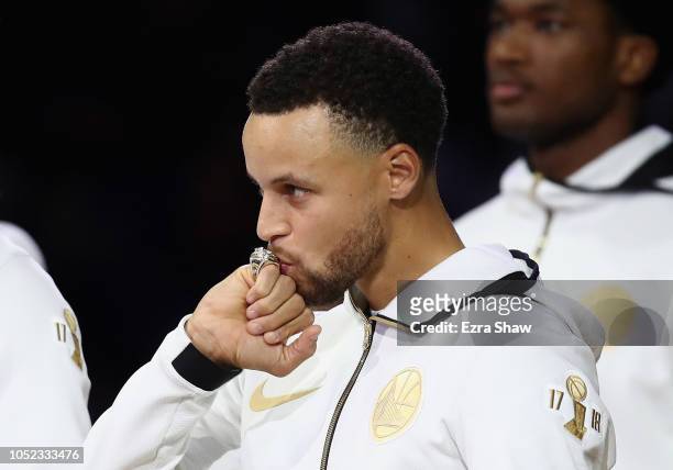 Stephen Curry of the Golden State Warriors kisses his 2017-2018 Championship ring prior to their game against the Oklahoma City Thunder at ORACLE...
