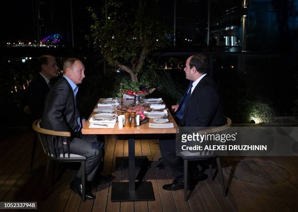Russian President Vladimir Putin speaks with Egyptian President Abdel Fattah Al-Sisi during their informal dinner in Sochi, on October 16, 2018.
