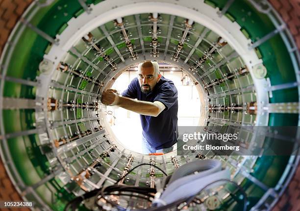 Janos Poczos, a technician, assembles the body coil of an MRI scanner at the Philips Healthcare production facility in Best, Netherlands, on Tuesday,...