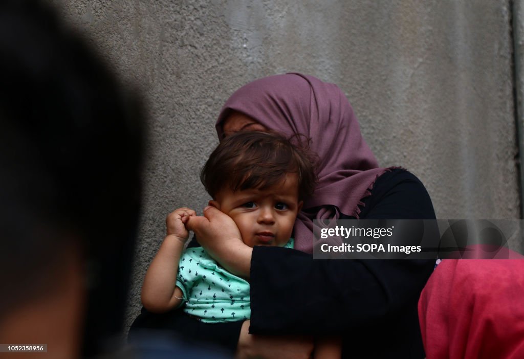 A woman holding her child seen crying during the funeral of...