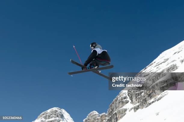 vista laterale del giovane sciatore in stile libero che pratica la grande aria - freestyle skiing foto e immagini stock