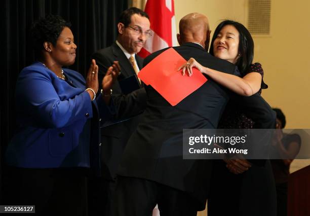 District of Columbia Public Schools Chancellor Michelle Rhee is hugged by Mayor Adrian Fenty as City Council Chairman Vincent Gray and Deputy Public...