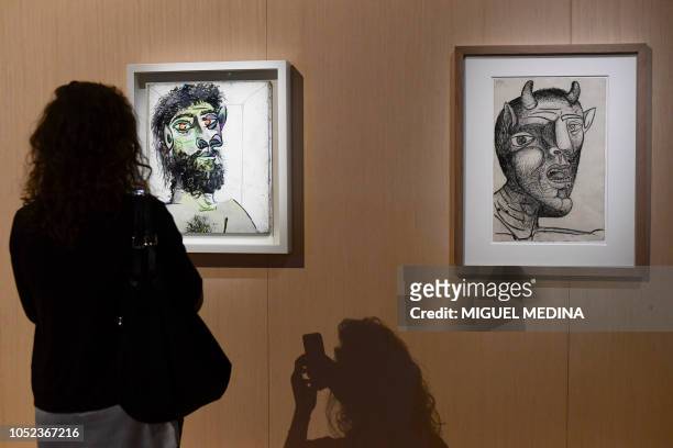 Visitor takes pictures of Pablo Picasso's 1956 "Head of a Bearded Man" and "Minotaur" during a preview of the exhibition "Picasso Metamorphosis" at...