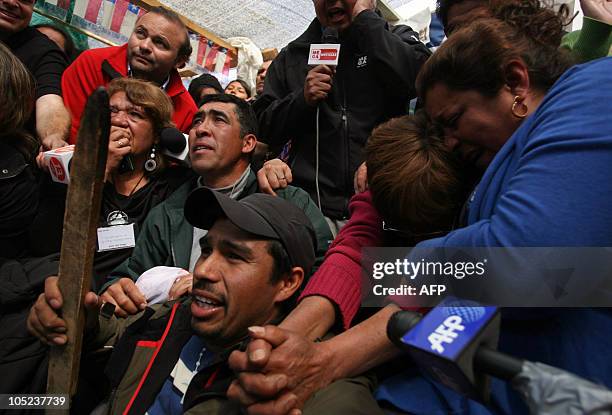 Relatives of miner Carlos Barrios react while he is brought to surface from the San Jose mine, near Copiapo, Chile, on October 13, 2010. Pumping...