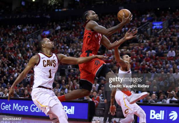 Kawhi Leonard of the Toronto Raptors shoots the ball as Rodney Hood and George Hill of the Cleveland Cavaliers defend during the second half of the...