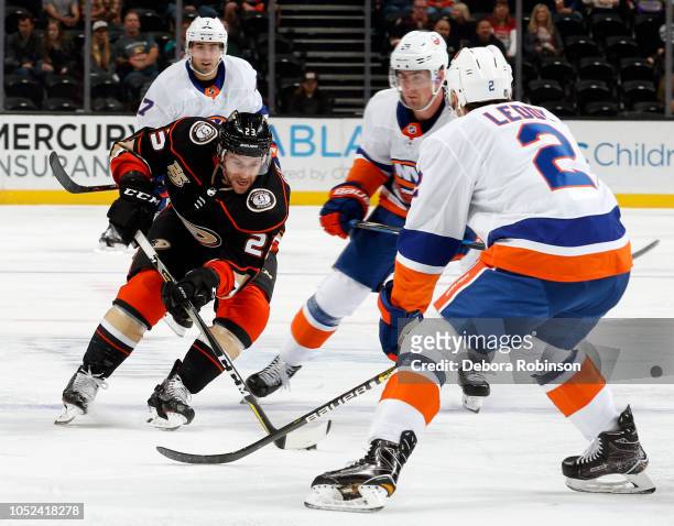Brian Gibbons of the Anaheim Ducks skates with the puck against Brock Nelson and Nick Leddy of the New York Islanders during the game on October 17,...