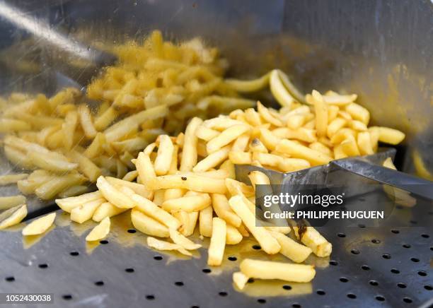 Picture taken in a food truck in Steenvoorde, northern France on October 15, 2018 shows French fries as the harvest of potatoes reduced following...