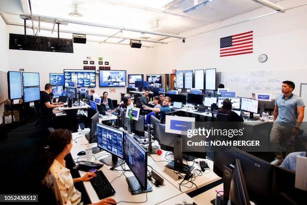 Employees work in Facebook's "War Room," during a media demonstration on October 17 in Menlo Park, California. - The freshly launched unit at...