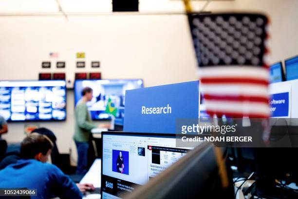 Employees work in Facebook's "War Room," during a media demonstration on October 17 in Menlo Park, California. - The freshly launched unit at...
