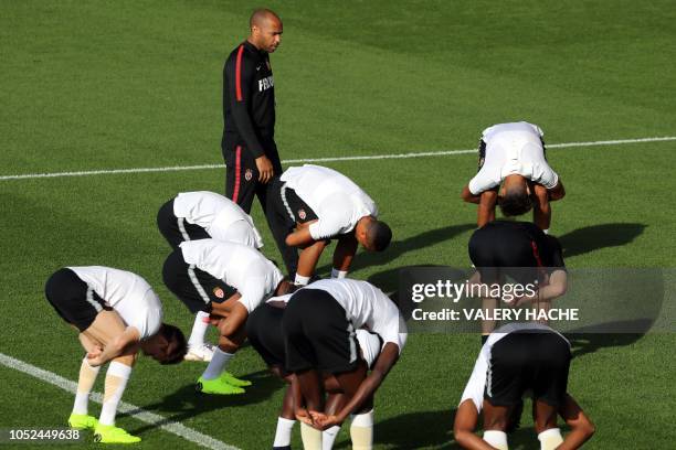 Monaco's French coach Thierry Henry stands past his players stretching during a training session in La Turbie, near Monaco on October 18, 2018. - The...