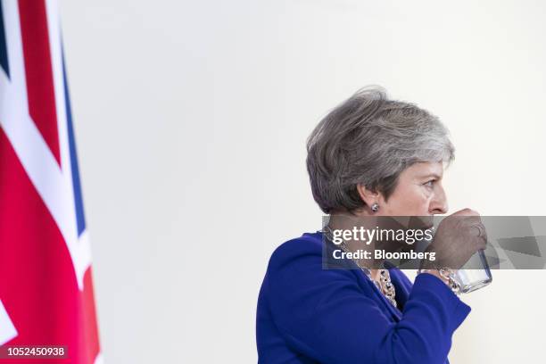 Theresa May, U.K. Prime minister, sips a glass of water during a news conference at a European Union leaders summit in Brussels, Belgium, on...