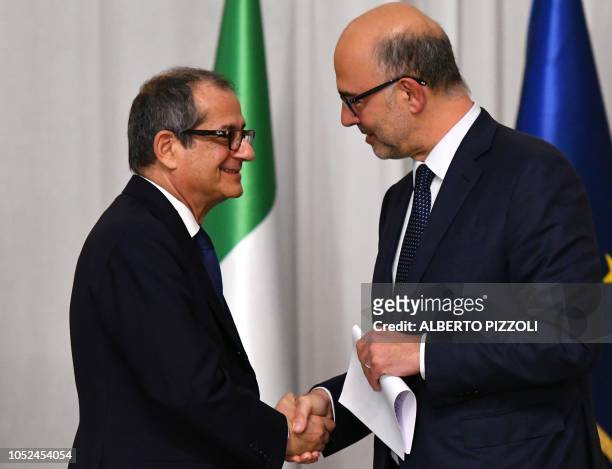 Italy's Minister of Economy and Finances, Giovanni Tria and European Affairs Commissioner, Pierre Moscovici shake hands during a press conference...