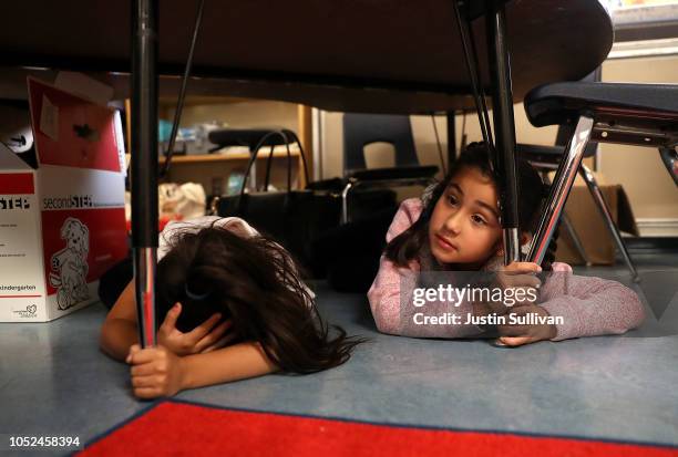 Students at Bryant Elementary School take cover under their desks during an earthquake drill as part of the Great ShakeOut event on October 18, 2018...