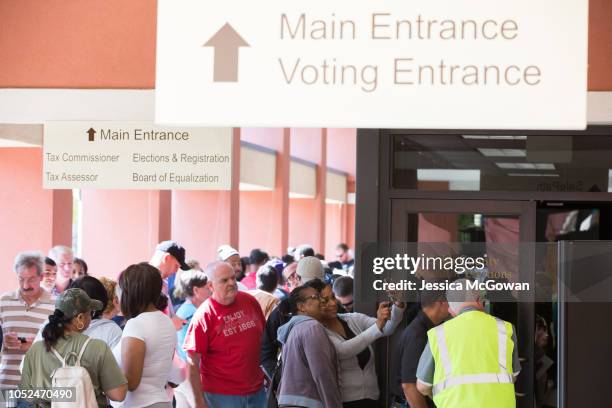 Voters wait in line for up to two hours to early vote at the Cobb County West Park Government Center on October 18, 2018 in Marietta, Georgia. Early...