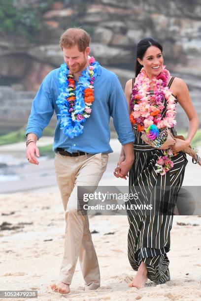 Britain's Prince Harry and his wife Meghan, Duchess of Sussex meet members of a local surfing community group, known as OneWave, who raise awareness...