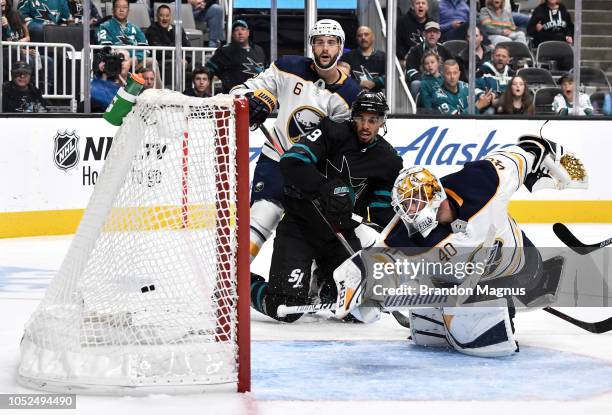 Marco Scandella of the Buffalo Sabres and Evander Kane of the San Jose Sharks watch the shot go past Carter Hutton of the Buffalo Sabres at SAP...